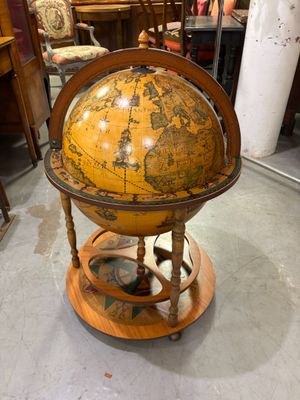 un vieux globe terrestre posé sur un socle dans une pièce