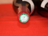 two bottles of wine sitting on a red cloth
