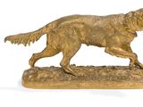 statue d'un golden retriever en train de courir, posée sur un socle en pierre