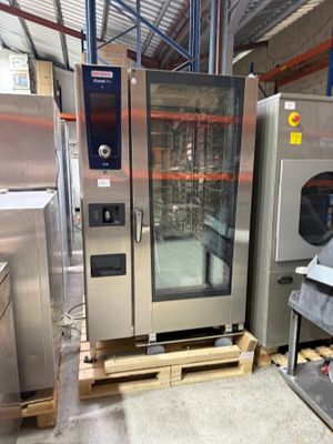 several stainless steel ovens in a large industrial kitchen with lots of shelves