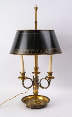 une lampe de table noire et dorée, munie d'un abat-jour noir