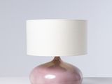 une lampe de table rose surmontée d'un abat-jour blanc