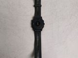 the watch is laying on a white surface with a black band