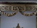 a table with a marble top and ornate carvings on it