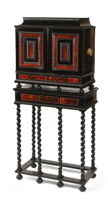 une armoire ancienne noire et rouge à deux tiroirs, posée sur un socle