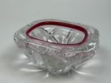a glass bowl with a red rim sitting on a table