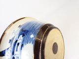 un vase bleu et blanc posé sur une surface blanche