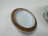a white plate with a brown rim next to a white plate with a brown rim