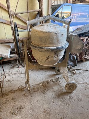 une bétonnière garée dans un garage à côté d'une voiture bleue