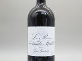 une bouteille de vin rouge posée sur une table blanche