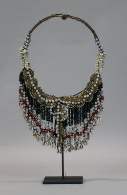 a close up of a necklace on a stand on a white background