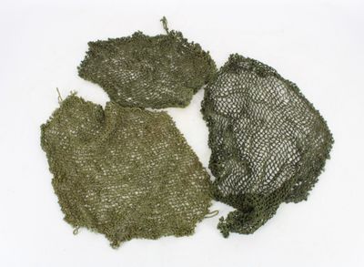 three pieces of green fabric on a white surface