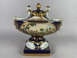 a blue and white vase with a gold decoration on it