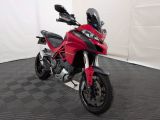 une photo d'une moto rouge garée dans une pièce