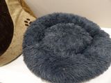 a dog bed that is on a table next to a pillow