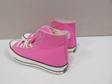 pink high top converse sneakers with white laces on a white surface