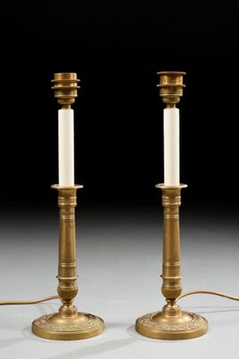 pair of antique brass candlesticks with white candles