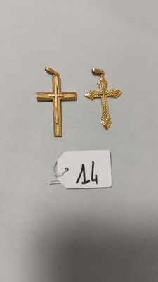deux croix dorées et une étiquette sur un fond blanc