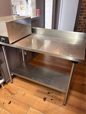 une table en acier inoxydable sur laquelle se trouve un grille-pain