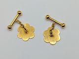 two pairs of gold plated flower earrings on a white surface