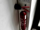 un extincteur fixé à la porte d'un immeuble