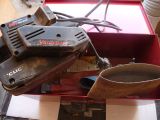 a box with a drill and other tools in it