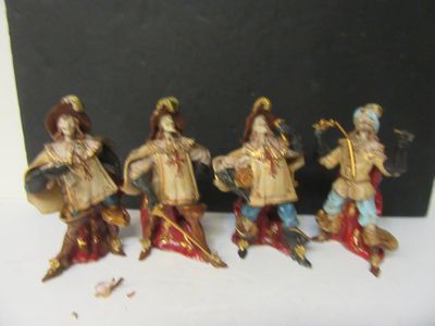 five figurines of people dressed in different costumes