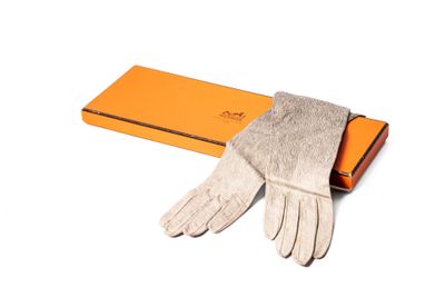 une boîte orange sur laquelle sont posés une paire de gants