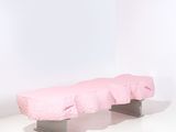 un banc rose dans une pièce blanche aux murs blancs