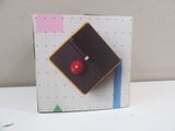 a box with a red button on it on a table