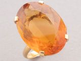 a close up of a ring with an orange stone on it