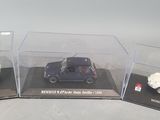 three miniature cars in a display case on a table
