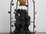 une statue posée sur une table avec une lampe