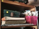 a stack of books on a shelf next to a basket of luggage