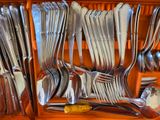 many forks and spoons in a wooden box