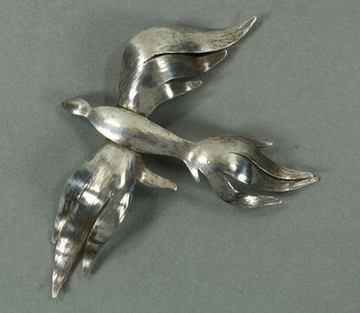 une broche en forme d'oiseau en argent, dotée de deux ailes