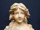 a statue of a woman with a bird on her head