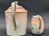 a white pitcher and a creamer sitting next to each other