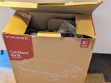 une boîte en carton contenant une paire de chaussures, posée par terre