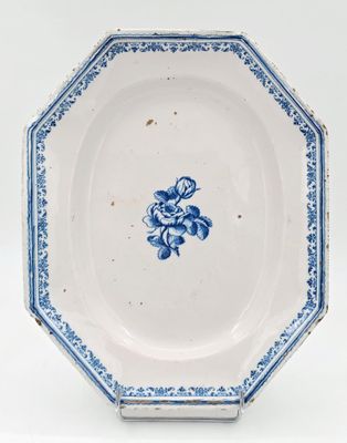 une vieille assiette bleue et blanche ornée d'un motif floral