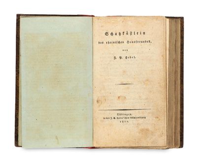 an old book with a green cover sitting on top of a table