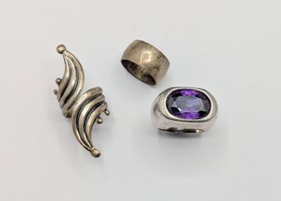 two rings and a ring with a purple stone on a white surface