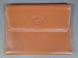 tan leather business card case with a logo on the front