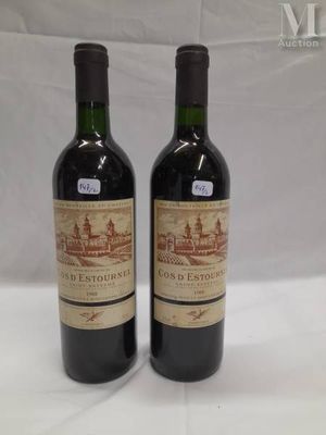 two bottles of red wine sitting on top of a white table