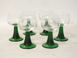 four green wine glasses sitting on top of each other on a table