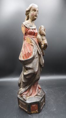 une statue ancienne d'une femme tenant un bébé dans ses bras