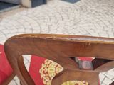 a wooden chair with a red cushion on it
