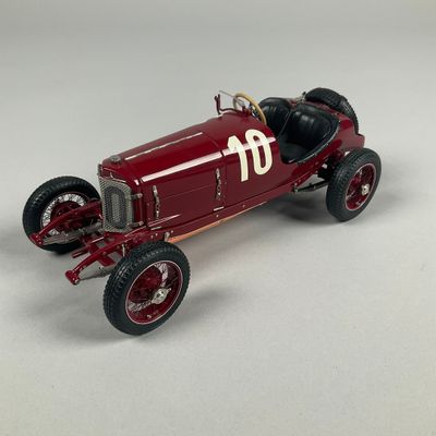 a red model of a racing car on a white surface