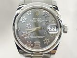 a silver watch with a floral pattern on it