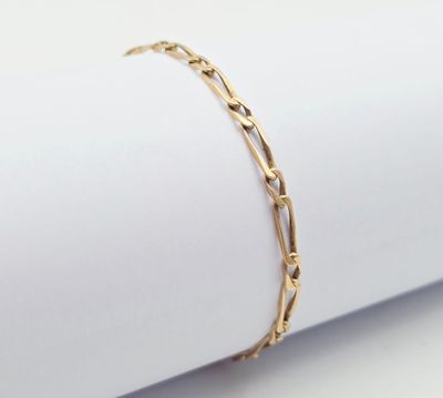 un bracelet en or posé sur une serviette, sur une surface blanche